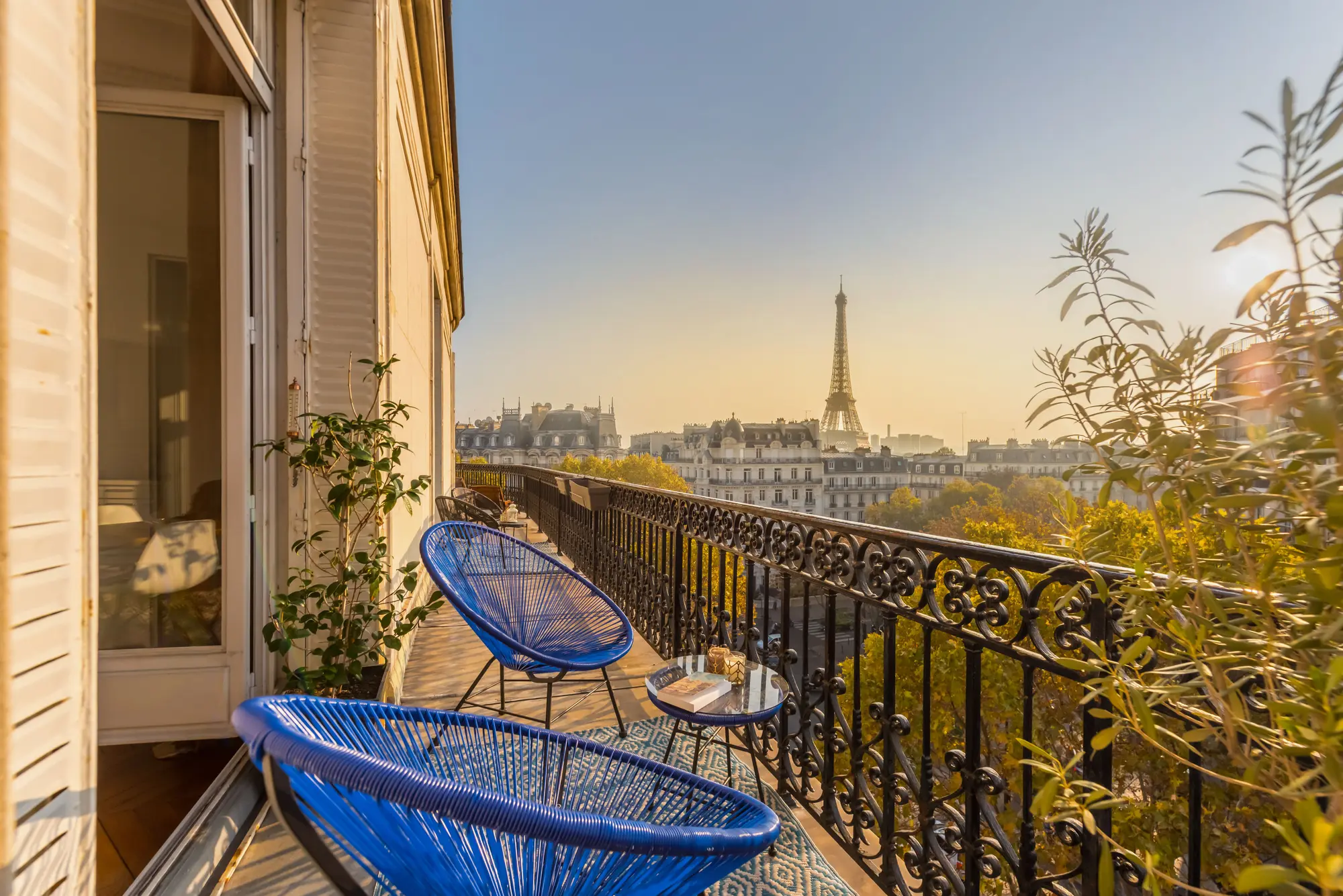 A Paris apartment balcony at golden hour, with the Eiffel Tower in the distance.