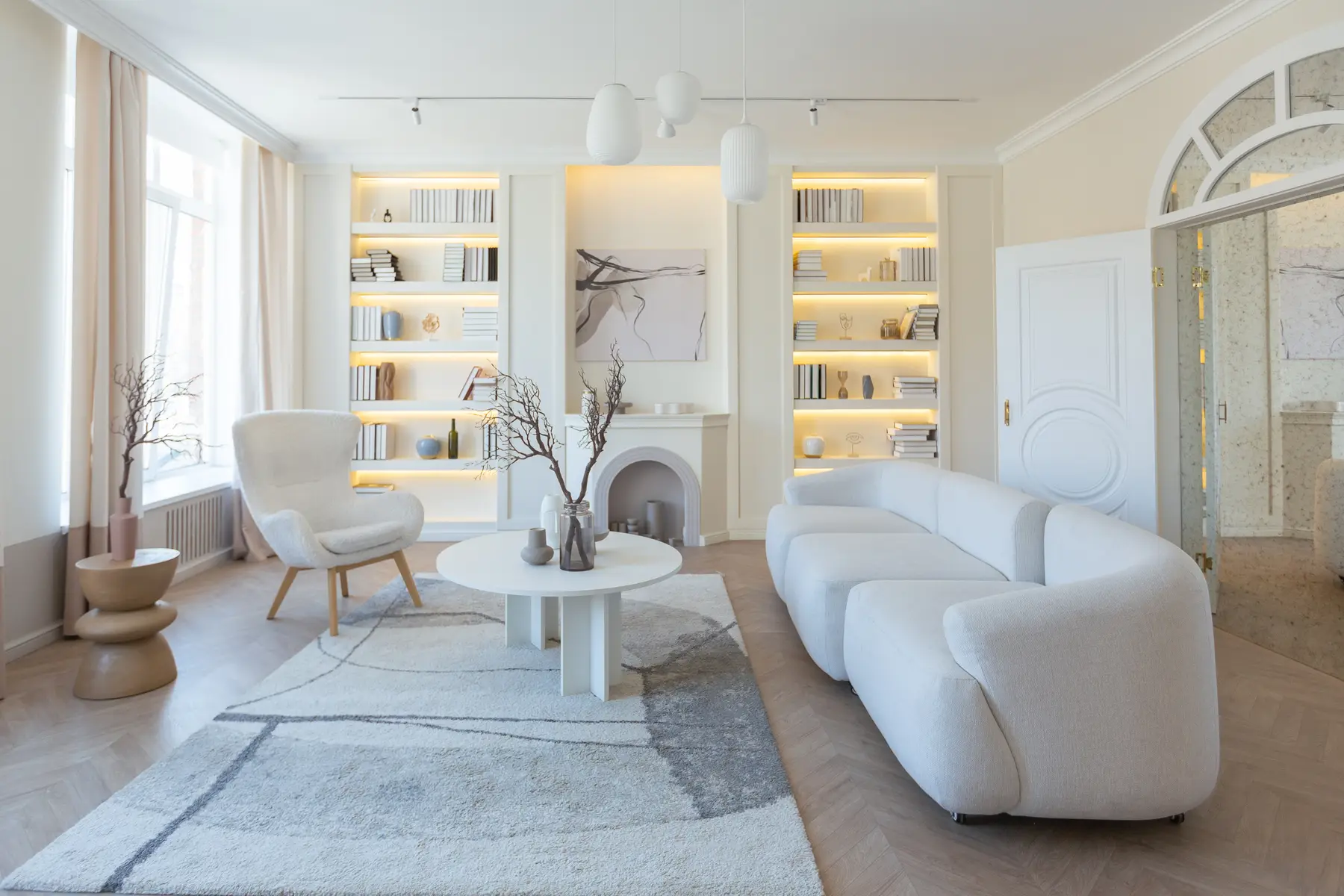 A renovated Haussmann living room in soft light, with original moldings and a marble fireplace.